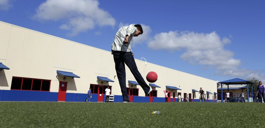 FILE - In this Sept. 10, 2014 file photo, children play kickball at the Karnes County Residential Center, a temporary home for immigrant women and children detained at the border, in Karnes City, Texas. Immigrant rights lawyers are asking a federal judge to appoint a special monitor to oversee a longstanding legal agreement related to the detention of immigrant children caught crossing the U.S.-Mexico border, an agreement at the center of lawsuit to be debated in a California appeals court next month. (AP Photo/Eric Gay, File)