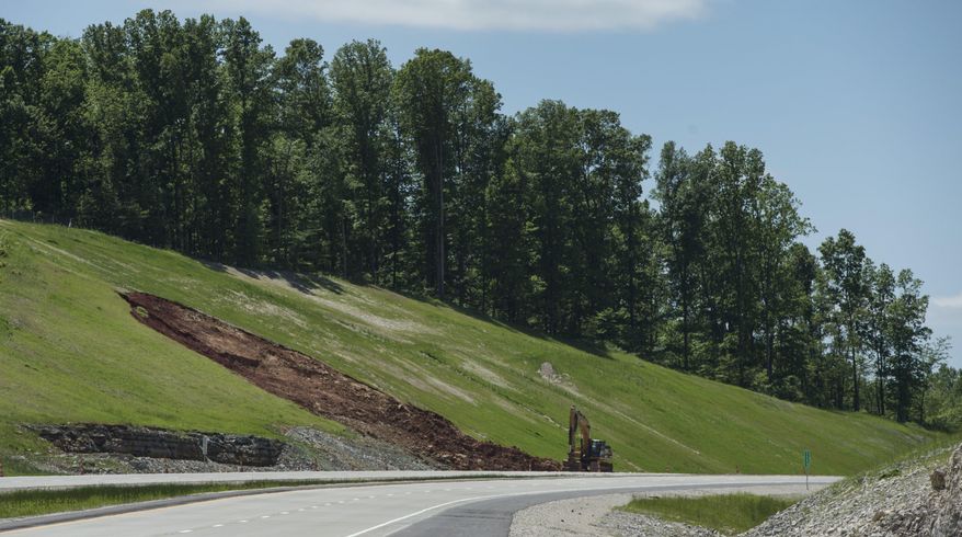In this May 13, 2016 photo, erosion has created a gash in the hillside along the new Interstate 69 section 4 near Bloomington, Ind. Will Wingfield, Indiana Department of Transportation spokesman, said rain, combined with additional drainage from geological features in that area, caused the soil to slump. The area will be filled with rock to alleviate future problems. (Chris Howell/Bloomington Herald-Times via AP)
