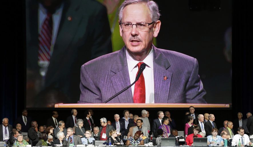 Bishop Bruce Ough, from the Dakotas-Minnesota church district and president of the Methodist Council of Bishops, is visible on a large monitor above attendees as he reads a recommendation regarding the churches stance on LGBT issues in Portland, Ore., Wednesday, May 18, 2016. The United Methodist Church, the nation's largest mainline Protestant denomination, is holding its once-every-four-years meeting here. It is facing a bitter fight over whether they should lift the church ban on same-sex marriage. (AP Photo/Don Ryan)