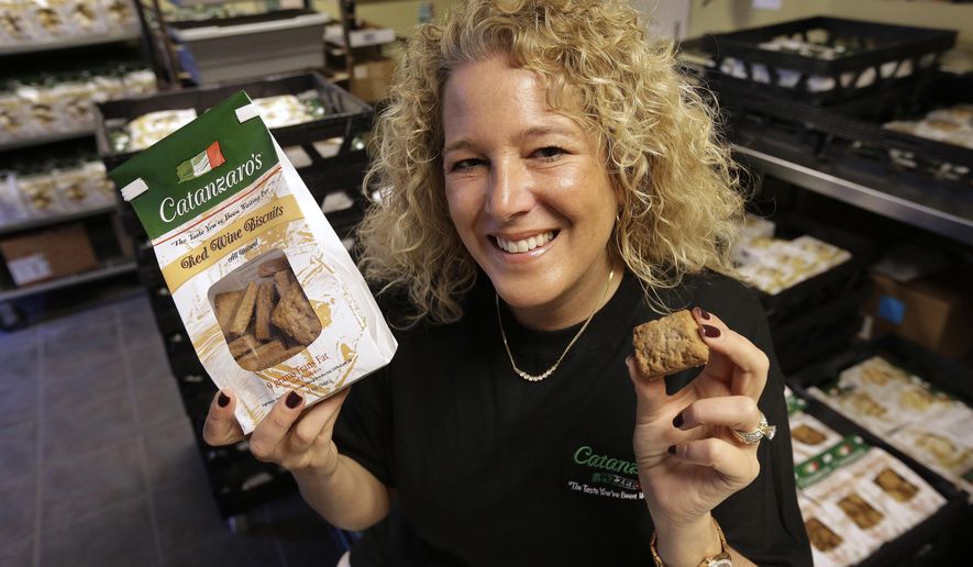 In this Tuesday, May 17, 2016 photo Kristen Catanzaro, of North Providence, R.I., displays wine biscuits in the packing room of her baking facility, in Pawtucket, R.I. The Rhode Island Senate is scheduled to vote Wednesday, May 18 on a bill that would allow bakers to get a special license to bypass existing wholesale alcohol restrictions to purchase up to 2,000 gallons of wine a year if it's used to make the traditional cookies. (AP Photo/Steven Senne)