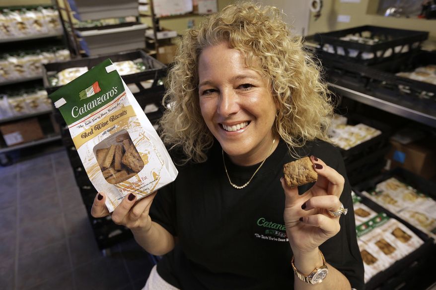 In this Tuesday, May 17, 2016 photo Kristen Catanzaro, of North Providence, R.I., displays wine biscuits in the packing room of her baking facility, in Pawtucket, R.I. The Rhode Island Senate is scheduled to vote Wednesday, May 18 on a bill that would allow bakers to get a special license to bypass existing wholesale alcohol restrictions to purchase up to 2,000 gallons of wine a year if it's used to make the traditional cookies. (AP Photo/Steven Senne)