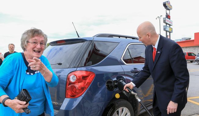 Nebraska Gov. Pete Ricketts pumps E-85 ethanol blend fuel into a car whose driver reacts to the presence of photographers, while visiting the Sapp Brothers Travel Center in Omaha, Neb., Thursday, May 19, 2016, to promote renewable fuels month in Nebraska. (AP Photo/Nati Harnik) ** FILE **