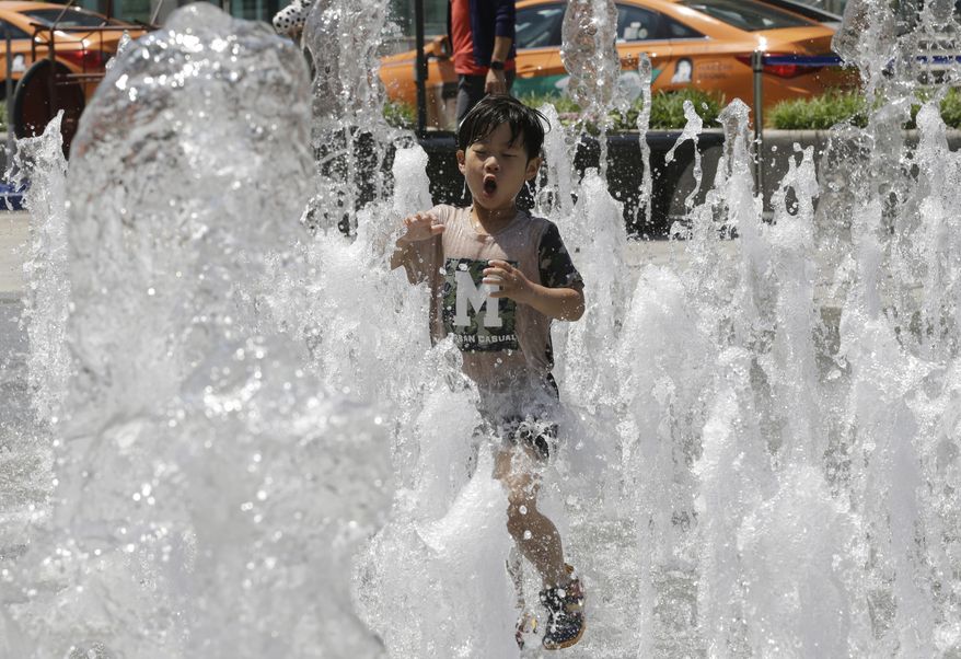 A boy plays in a fountain to beat the summer heat in Seoul, South Korea, Thursday, May 19, 2016. A heat wave warning was issued in Seoul as temperatures soared above 32 degrees Celsius (90 degrees Fahrenheit). (AP Photo/Ahn Young-joon)