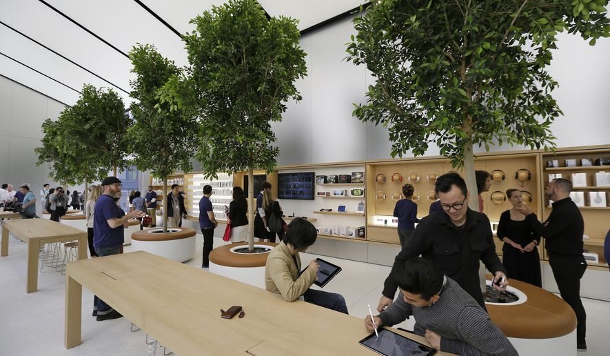 People try products in the "Genius Grove" during a preview of the new Apple Union Square store, Thursday, May 19, 2016, in San Francisco. Apple is getting ready to unveil a stylish new product that's not for sale, a new look for its stores. The iPhone maker is overhauling its nearly 480 stores worldwide, starting with its new location in San Francisco. (AP Photo/Eric Risberg)