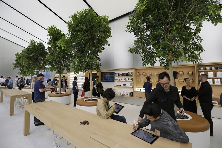 People try products in the "Genius Grove" during a preview of the new Apple Union Square store, Thursday, May 19, 2016, in San Francisco. Apple is getting ready to unveil a stylish new product that's not for sale, a new look for its stores. The iPhone maker is overhauling its nearly 480 stores worldwide, starting with its new location in San Francisco. (AP Photo/Eric Risberg)
