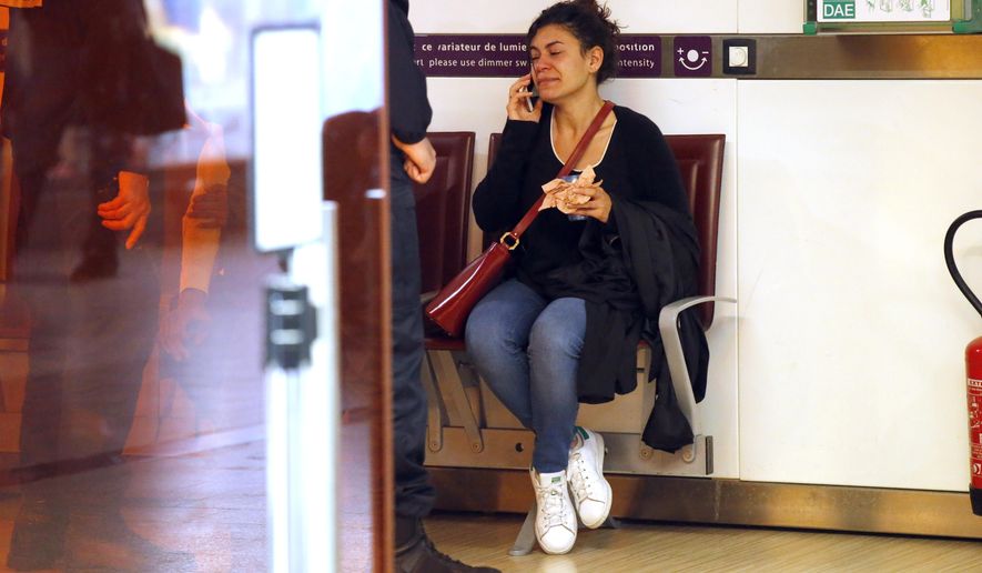 A relative of the victims of the EgyptAir flight 804 that crashed, reacts as she makes a phone call at Charles de Gaulle Airport outside of Paris, Thursday, May 19, 2016. Egyptian aviation officials say an EgyptAir flight from Paris to Cairo with 66 passengers and crew on board has crashed. (AP Photo/Michel Euler)