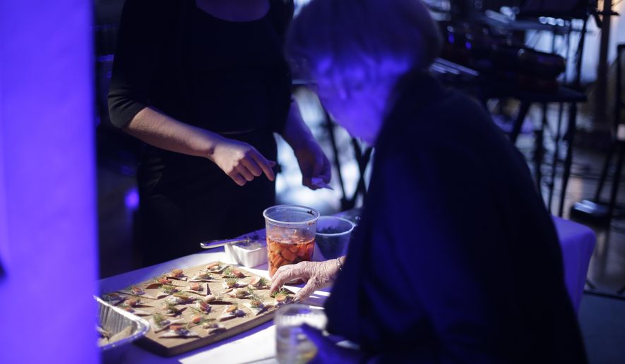 In this Monday, May 16, 2016 photo, a patron tries food by chef Jonah Reider during Brownstone, an experiential treasure-hunt of sound, taste, and color at the American Irish Historical Society, in New York. The Columbia University student who wowed food experts with sublime creations served in his spartan dorm has graduated. Reider already has thousands of fans, including Stephen Colbert and famed food critic Ruth Reichl. (AP Photo/Frank Franklin II)
