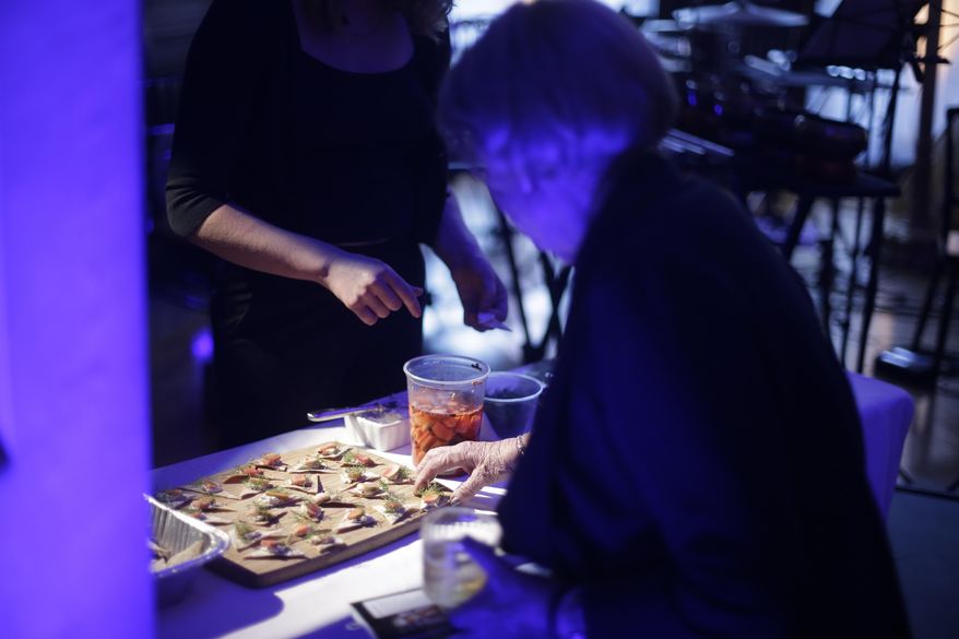 In this Monday, May 16, 2016 photo, a patron tries food by chef Jonah Reider during Brownstone, an experiential treasure-hunt of sound, taste, and color at the American Irish Historical Society, in New York. The Columbia University student who wowed food experts with sublime creations served in his spartan dorm has graduated. Reider already has thousands of fans, including Stephen Colbert and famed food critic Ruth Reichl. (AP Photo/Frank Franklin II)