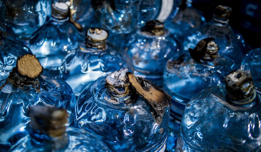 Five-gallon jugs sit scorched after an arson attempt on the bottled water supply being distributed at Greater Holy Temple Church of God and Christ, on Flint's north side during the city's water crisis on Wednesday, May 18, 2016, in Flint, Mich. This is the second time the water supply has had an attempted arson this month. (Jake May/The Flint Journal-MLive.com via AP) LOCAL TELEVISION OUT; LOCAL INTERNET OUT; MANDATORY CREDIT