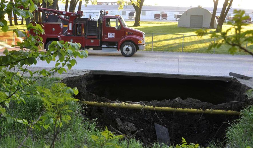 In this Wednesday, May 18, 2016 photo, a sinkhole forces the closure of a street in Fort Dodge, Iowa. (Chad Thompson /The Messenger via AP) MANDATORY CREDIT