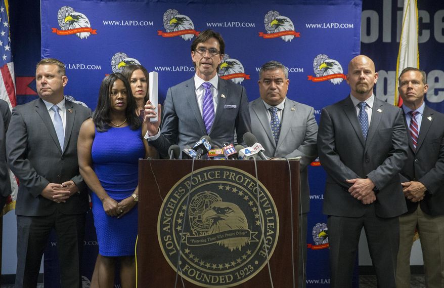 Attorney Gregg Adam, center at podium, surrounded by officials with Los Angeles Police Protective League, the union representing the rank and file of the Los Angeles Police Department, announce a lawsuit against the city and police chief during a news conference on Thursday, May 19, 2016, in Los Angeles. The union filed a lawsuit in federal court, challenging the structure of the LAPD's Board of Rights, a three-person panel charged with deciding discipline cases for officers facing long-term suspension or termination. (AP Photo/Damian Dovarganes)
