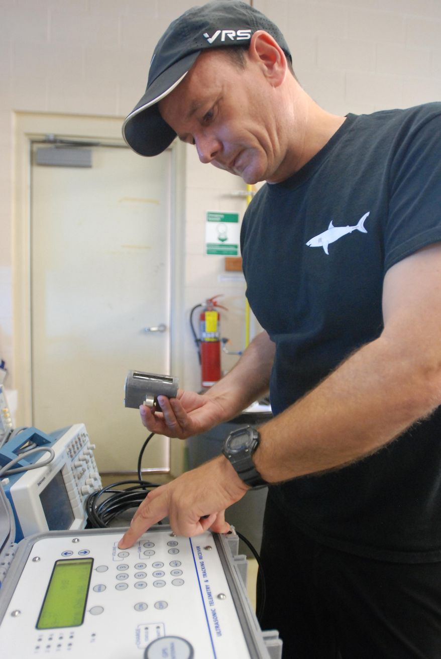 In this Thursday, Jan. 21, 2016 photo, Carl Meyer, a shark researcher at the University of Hawaii’s Institute of Marine Biology, shows a tracking device used to monitor tiger shark around Hawaii at his lab on Oahu’s Coconut Island. Meyer was the principle investigator for a 2-year study released Thursday, May 19, 2016 that looked at tiger shark activity around Maui after a number of shark bites in 2012 and 2013 promoted the state to commisson further research. (AP Photo/Caleb Jones)