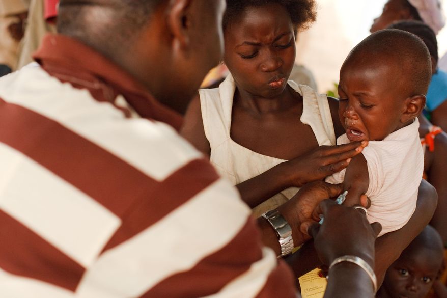 FILE- In this Saturday, Jan. 22, 2011 file photo, a health worker injects a young boy with yellow fever vaccine in Seguela in northern Ivory Coast. On Thursday, May 19, 2016 the UN health agency convened an expert committee to consider whether the epidemic of yellow fever, an acute viral hemorrhagic fever, qualifies as an international public health emergency. (AP Photo/Olivier Asselin, File)