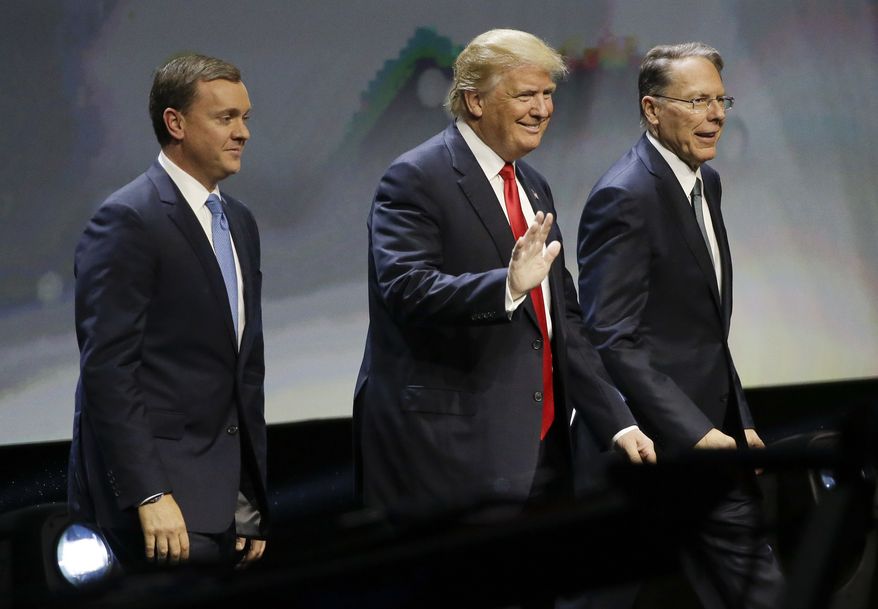 Republican presidential candidate Donald Trump is introduced by National Rifle Association executive director Chris W. Cox (left) and NRA executive vice president Wayne LaPierre as he takes the stage to speak at the NRA convention on May 20 in Louisville, Ky. (Associated Press)