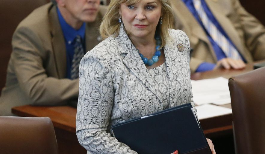 In this Wednesday, May 18, 2016 photo, Oklahoma Gov. Mary Fallin walks on the floor of the Oklahoma House in Oklahoma City. A bill awaiting Fallin's signature that would make it a felony for a doctor to perform an abortion has been described by critics as the first of its kind in the nation, but such measures are not uncommon in a state that GOP leaders like to describe as the reddest of the red.(AP Photo/Sue Ogrocki)