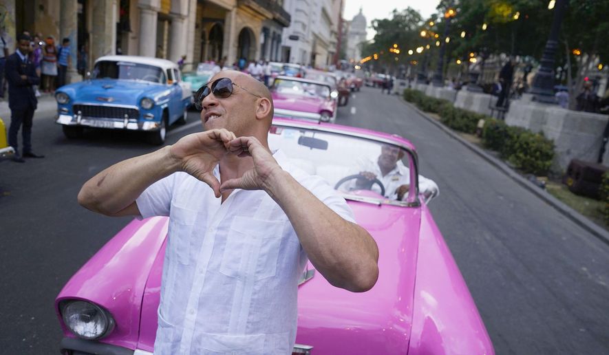 FILE - In this May 3, 2016, file photo, U.S. Actor Vin Diesel flashes a heart-in-hand to the crowd ahead of the presentation of fashion designer Karl Lagerfeld's "cruise" line for fashion house Chanel, along Paseo del Prado street in Havana, Cuba. The mostly foreign audience arrived in specially hired classic American cars. Havana residents had to watch from behind police lines more than a block away. (AP Photo/Ramon Espinosa, File)