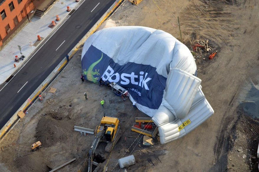 This photo provided by the Philadelphia Police Department shows a blimp that made an emergency landing and deflated at a construction site next to a Philadelphia highway. No injuries have been reported on the two-passenger blimp or on the ground where it landed, near the SugarHouse Casino. The blimp floated over the Delaware River on Friday, May 20, 2016, before going down in the Fishtown neighborhood. (Lt. Dave Bonk/Philadelphia Police Department via AP)