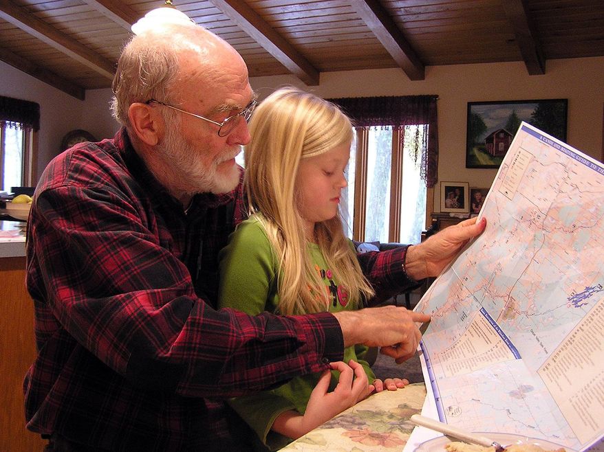 FOR RELEASE SATURDAY, MAY 21, 2016, AT 12:01 A.M. CDT. - This photo taken Oct. 22, 2009, shows retired biology teacher Leonard Anderson and his granddaughter Kylli, looking at a map to see where she caught a big catfish the summer before. Kylli wanted to eat the fish, but the St. Louis River has mercury advisories, warning pregnant women and young children not to eat certain fish. Anderson says if Minnesota allows copper-nickel mining, the mercury in the fish will only get worse. (Stephanie Hemphill/Minnesota Public Radio via AP) MANDATORY CREDIT