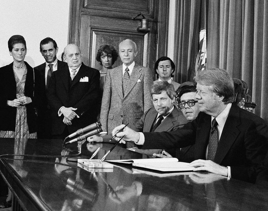 FILE - In this June 1, 1977 file photo, President Jimmy Carter prepares to sign the American Convention on Human Rights at the Pan American Building, in Washington. From left are: Chile Amb. Maria Eugenia Oyarzun; unidentified aide; Nicaraguan Amb. Guillermo Sevilla-Sacasa; Patricia Derian, U.S. Women's Rights coordinator; Paraguay Amb. Marion Lopez Escobar; Marcelo Huergo, OAS staff; Gale McGee, U.S. ambassador to the OAS; Juan Pablo Gomez, OAS council chairman; Carter; and Alejandro Orfila, OAS secretary general (not pictured). Derian, who actively supported Mississippi public school desegregation and served as assistant secretary of state for human rights during the Carter administration, has died. Derian's son, Michael Derian, confirmed his mother died early Friday, May 20, 2016. She was 86. (AP Photo, File)