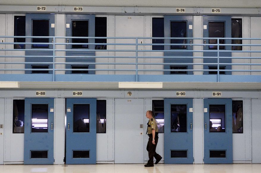 In this Nov. 13, 2013 photo, a guard checks on inmates at the Jameson Annex of the South Dakota State Penitentiary in Sioux Falls, S.D. According to corrections officials, better pay for prison guards is helping reduce turnover at South Dakota's state prisons. In 2013, annual turnover rate for corrections officers at the South Dakota State Penitentiary in Sioux Falls peaked at about 35 percent. Since then, the department has increased starting pay each year. (Elisha page/The Argus Leader via AP) NO SALES; MANDATORY CREDIT