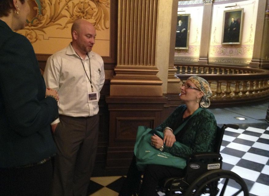 In this May 17, 2016 photo, Ovarian cancer patient Amy Harvey, right, visits the Capitol to advocate for oral chemotherapy parity legislation in Lansing, Mich. Cancer patients and survivors are lobbying lawmakers to make Michigan the latest in a long line of states to require equal insurance coverage of chemotherapy regardless of whether the drugs are given by needle or taken orally. (AP Photo/David Eggert)
