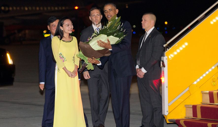 President Obama is given flowers by Linh Tran, the ceremonial flower girl, as he arrives Sunday at Noi Bai International Airport in Hanoi, Vietnam. (Associated Press)