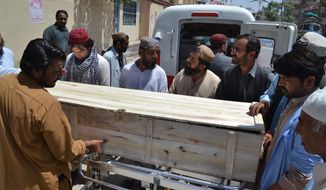 People stand near a coffin carrying a body one of the victims in a reportedly U.S. drone strike in the Ahmad Wal area in Baluchistan province of Pakistan, at a local hospital in Quetta, Pakistan, Sunday, May 22, 2016. A senior commander of the Afghan Taliban confirmed on Sunday that the extremist group&#39;s leader, Mullah Mohammad Akhtar Mansour, has been killed in the  strike. (AP Photo/Arshad Butt)