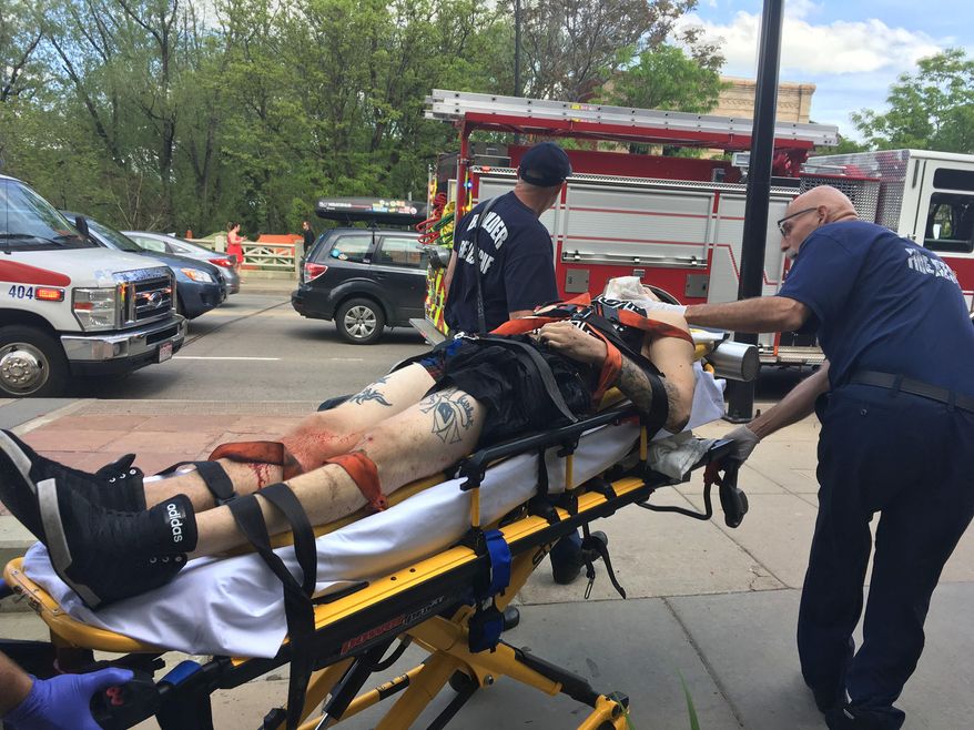 Paramedics wheel away a wounded suspect at the scene where the man was shot by police, under a bridge in downtown Boulder, Colo., Sunday, May 22, 2016. According to the Boulder Police Department, police responded after the man discharged a gun into Boulder Creek, and then after the man pointed his gun at an officer, police shot the man. (AP Photo/Brennan Linsley)