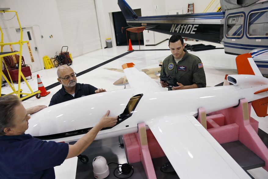In this May 19, 2016, photo, Joe Cummings, from left, Mike Lukens and Mike Toland, of National Security Technologies, a contractor for the National Nuclear Security Administration, work on a drone at the Remote Sensing Laboratory in Las Vegas. Officials from the Nevada National Security Site announced the purchase of two unmanned aerial vehicles as part of a test program to provide arial radiological monitoring in the event of an emergency. (AP Photo/John Locher)