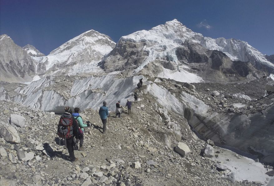 In this Monday, Feb. 22, 2016, file photo, international trekkers pass through a glacier at the Mount Everest base camp, Nepal. An Indian climber has died while being helped down Mount Everest, just hours after a Dutch and an Australian climber died near the peak. (AP Photo/Tashi Sherpa, File)
