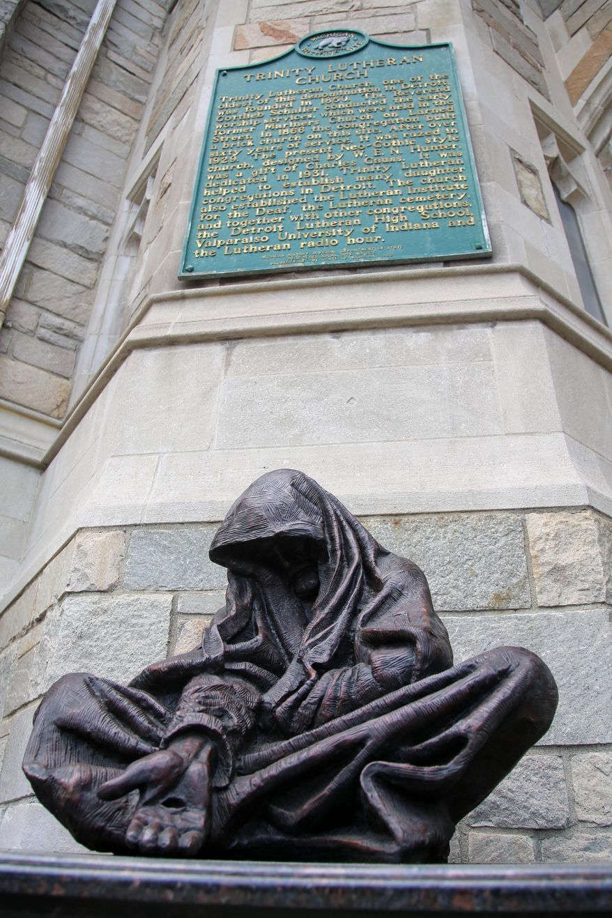 A bronze statue depicting Jesus as a homeless man is unveiled during the dedication ceremony of Sacred Art "Whatsoever You Do" by sculptor Timothy Schmalz in front of Trinity Lutheran Church in Detroit on Sunday, May 22, 2016. Last June, another sculpture by Schmalz titled "Homeless Jesus" was unveiled outside downtown's Ss. Peter and Paul Jesuit Catholic Church. (Kimberly P. Mitchell/Detroit Free Press via AP) DETROIT NEWS OUT; TV OUT; MAGS OUT; NO SALES; MANDATORY CREDIT DETROIT FREE PRESS