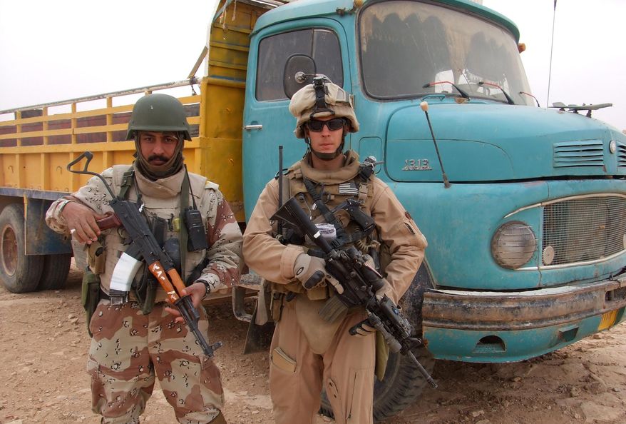 HOLD FOR USE WITH STORY MOVING FRIDAY, MAY 20, 2016-This 2007 photo provided by Chase Millsap shows Millsap with the Captain standing next to a suspected truck bomb following a successful raid in Al Anbar, Iraq. After three tours of duty in warn-torn Iraq, including one that nearly took his life, Millsap returned to the United States to earn a master's degree in public policy and get on with a civilian life. For the past two years, the former Green Beret soldier has been fighting another battle to gain political asylum for his brother in arms, a man he simply calls The Captain, a soldier who fought alongside him during two of Millsap's tours in Iraq. (Chase Millsap via AP)