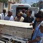 People stand near a coffin carrying a body one of the victims of a U.S. drone strike on May 22 in Quetta, Pakistan. A senior commander of the Afghan Taliban confirmed that the extremist group&#39;s leader, Mullah Mohammed Akhtar Mansour, was killed in the  strike. (Associated Press)
