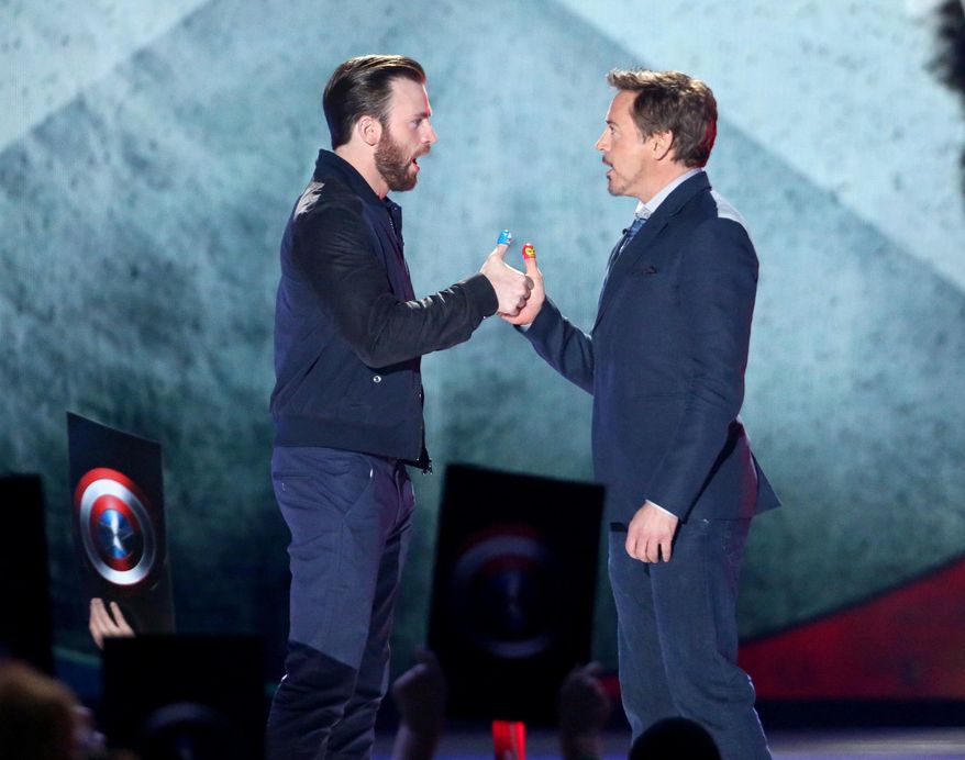 FILE - In this March 12, 2016, file photo, Chris Evans, left, and Robert Downey Jr. play thumb war at the Kids' Choice Awards at The Forum in Inglewood, Calif. KSWB-TV reported May 24, 2016, that the actors visited an ailing Avengers fan near San Diego on May 23, 2016. (Photo by Matt Sayles/Invision/AP, File )