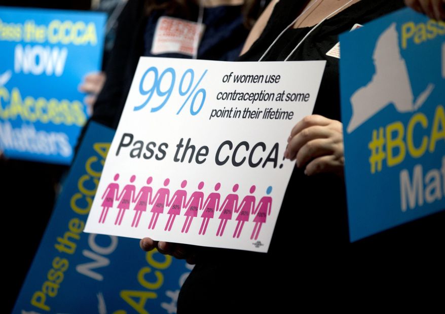 Reproductive rights advocates hold signs during a news conference at the state Capitol on Tuesday, May 24, 2016, in Albany, N.Y. (AP Photo/Mike Groll)