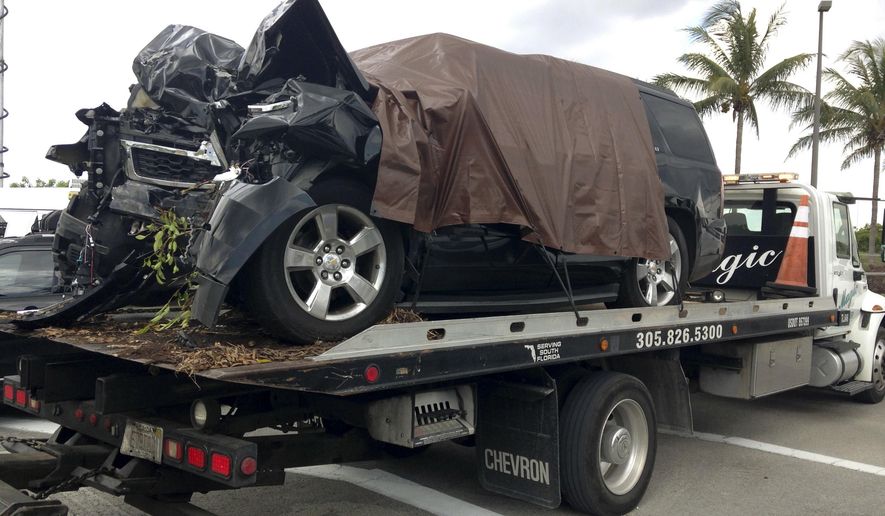 A tow truck leaves with City of Opa-locka Commissioner Terence Pinder's SUV after it crashed into a tree, Tuesday, May 24, 2016, at Miami-Opa Locka Executive Airport. Pinder was killed in a suspicious single-vehicle crash a day before he was scheduled to surrender in a criminal corruption case. Police said they are investigating whether the crash was deliberate. (AP Photo/Curt Anderson)