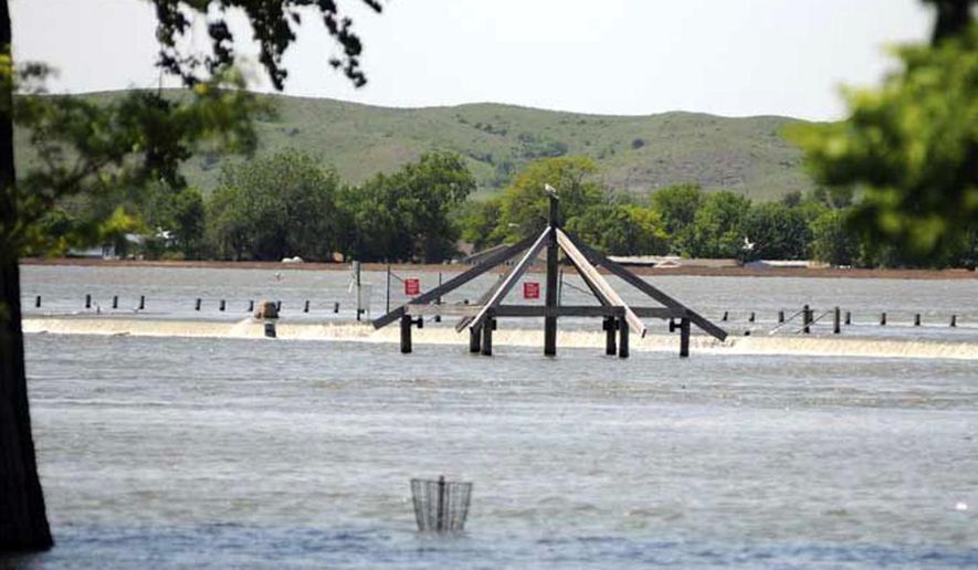 In this photo taken in 2011, water pours over the LaFramboise Island causeway in Pierre, S.D., as the Missouri River flooded it banks. Five years ago, flooding was on the horizon in Pierre and Fort Pierre, though officials had no idea how bad it would be. It turned out to be the worst flooding the neighboring cities have seen since the Missouri River Dam system was finished in the 1960s. (Chris Mangan/Capital Journal via AP) MANDATORY CREDIT