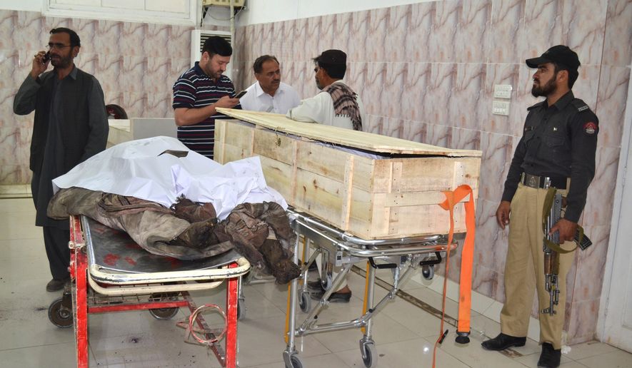 A Pakistani police officer and paramedics stand beside two dead bodies reportedly killed in a U.S. drone strike in the Ahmad Wal area in Baluchistan province, Pakistan, at a hopsital in Quetta, Pakistan, Sunday, May 22, 2016. A senior commander of the Afghan Taliban confirmed on Sunday that the extremist group's leader, Mullah Mohammad Akhtar Mansour, had been killed in the strike. (AP Photo/Arshad Butt)