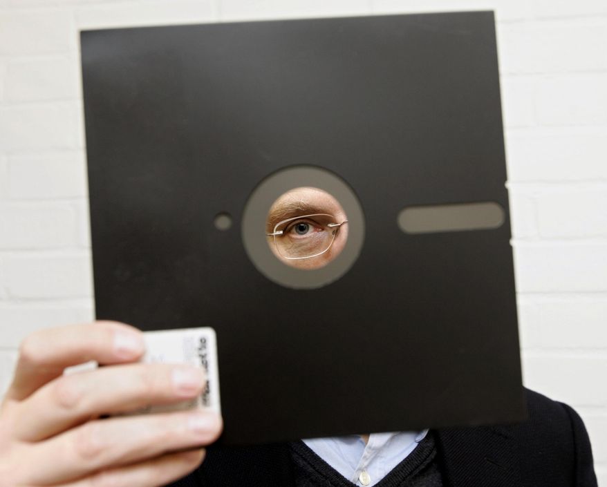 In this Nov. 16, 2004, file photo, an obsolete 8 and 1-half-inch floppy disk is held in London. (AP Photo/Adam Butler, File)