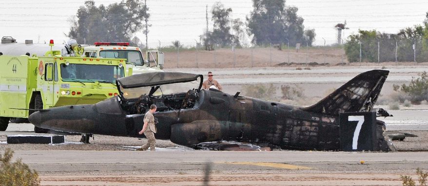 FILE - This March 11, 2015 file photo officials check the scene of a T-59 Hawk aircraft crash at the Marine Corps Air Station in Yuma, Ariz. In a report released Wednesday, May 25, 2016, federal investigators blame the Marine Corps, the Air Force and the pilot and operator of a privately-owned military jet for the death of a Marine killed last year when the jet crashed into his truck in Arizona. (Randy Hoeft/The Yuma Sun via AP, File) MANDATORY CREDIT