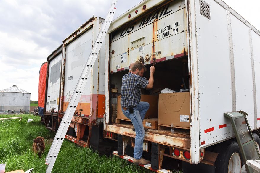 ADVANCE FOR SUNDAY MAY 29 AND THEREAFTER - In a Thursday, May 19, 2016 photo, Mike DeVries stores parts in trailers on his farmstead outside of Alvord, Iowa. DeVries sells parts on eBay to customers around the world. DeVries wasn't sure what to make of the precipitous drop in sales on some items. When he checked the competition, he found 12-volt solenoids from China selling for $3.29 on eBay. Not only were prices lower, the items were offered with free shipping through an "ePacket." (Jay Pickthorn/Argus Leader via AP)
