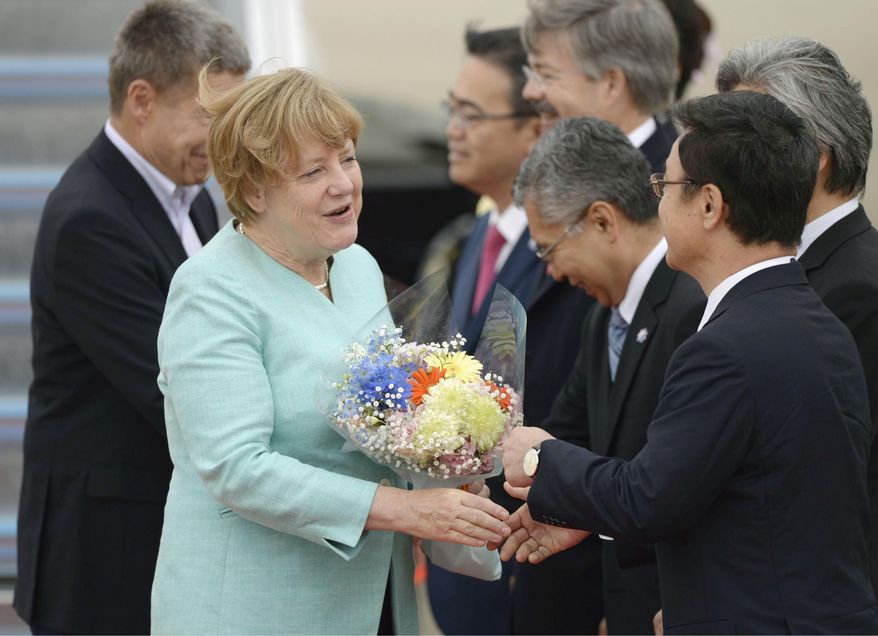 German Chancellor Angela Merkel, front left, is greeted by officials on her arrival at Chubu Centrair International Airport in Tokoname, Aichi prefecture, central Japan Thursday, May 26, 2016. Merkel will attend the Group of Seven meetings in the Ise-Shima region on May 26 and 27. (Takuya Inaba/Kyodo News via AP) JAPAN OUT, MANDATORY CREDIT