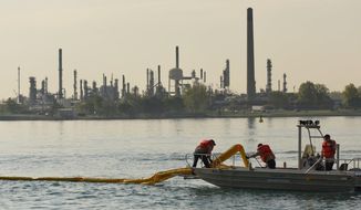 In this file photo, Enbridge Energy pipeline maintenance crews place an oil containment boom in the St. Clair River during a oil spill practice drill in Marysville, Mich. on Wednesday May 25, 2016.   (Tanya Moutzalias/MLive Detroit via AP) **FILE**
