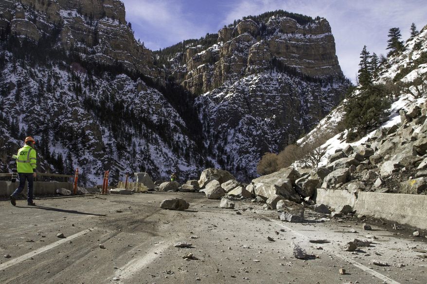 ADVANCE FOR SATURDAY, MAY 28- FILE - In this Wednesday, Feb. 17, 2016, file photograph, a Colorado Department of Transportation worker examines debris from a rock slide on Interstate 70 in Glenwood Canyon east of Glenwood Springs, Colo. All lanes of the interstate were reopened Wednesday, April 13, 2016, after the emergency work, which tallied $5 million, was completed 23 days ahead of schedule. The Glenwood Post-Independent has analyzed data from the state transportation department that shows Interstate 70 closes an average of every 2.4 days west of Denver. (Chelsea Self/Glenwood Springs Post Independent via AP, file) MANDATORY CREDIT