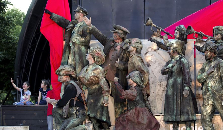 In this May 22, 2016, picture actors perform in Lenin's Arc play, staged by the Masca Theatre in Bucharest, Romania. Romanians relive the horrors of communism in a play featuring Lenin and Stalin, set to patriotic songs of that era, played by actors who mime their roles, the hour-long performance in a Bucharest park, also being a reminder for some that not everything was bad under communism.(AP Photo/Vadim Ghirda)