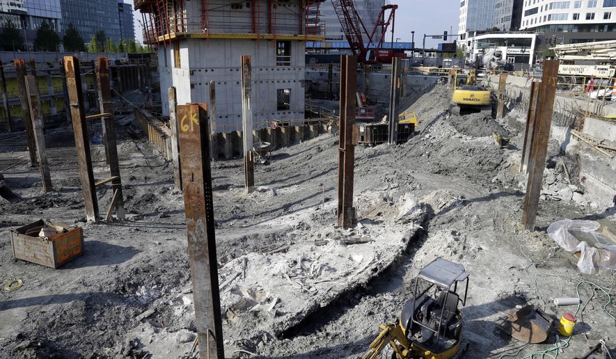 A shipwreck from the 1800s that has been uncovered during construction in the Seaport District is seen to the left of a construction vehicle, bottom, Wednesday, May 25, 2016, in Boston. According to city archaeologist Joe Bagley, it's the first time a shipwreck has been found in this section of Boston. Bagley says it appears the vessel was carrying lime, which was used for masonry and construction. (AP Photo/Elise Amendola)
