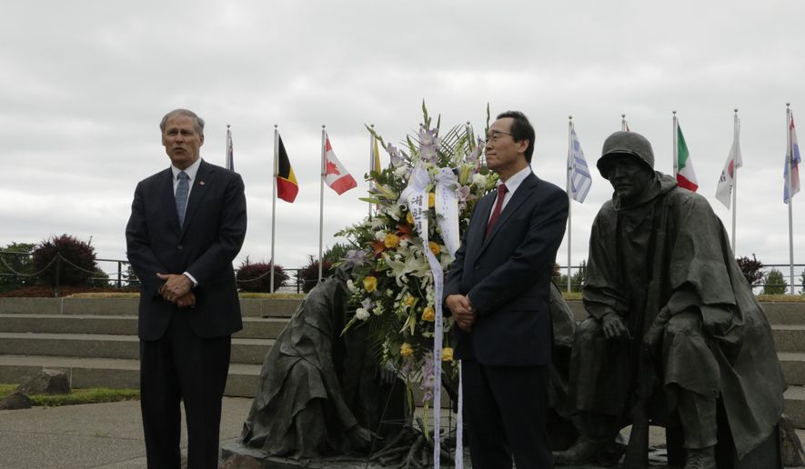 Washington Gov. Jay Inslee speaks to a group gathered at the Korean War Memorial, as Governor Ha Jin Song of the Jeollabuk-do province in South Korea looks on Wednesday, May 25, 2016, in Olympia, Wash. Inslee and Song placed a ceremonial wreath at the memorial as part of a daylong event to mark the 20-year anniversary of the sister-state agreement between the province and Washington state. (AP Photo/Rachel La Corte)