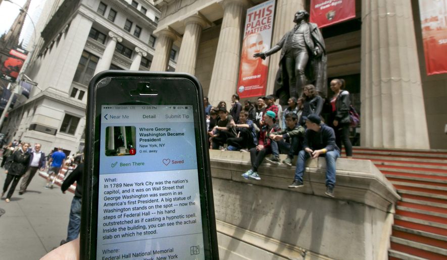 In this Tuesday, May 24, 2016, photo, the Roadside Presidents smartphone app directs people to the statue of George Washington on the steps of the Federal Hall National Monument, in New York's Financial District. Heading out for a holiday weekend road trip? There are a number of apps available to entertain and educate along the way. (AP Photo/Richard Drew)