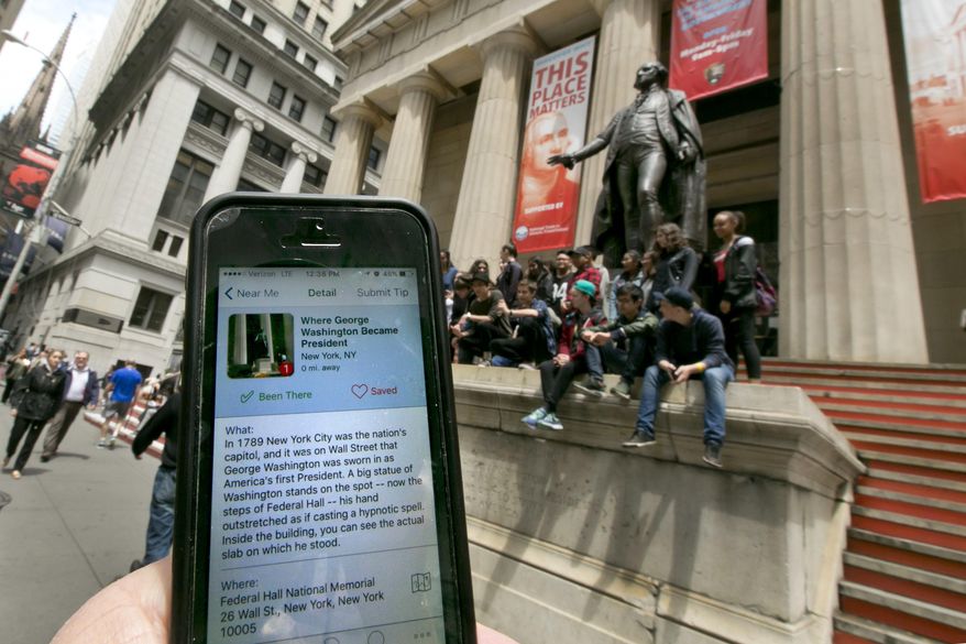 In this Tuesday, May 24, 2016, photo, the Roadside Presidents smartphone app directs people to the statue of George Washington on the steps of the Federal Hall National Monument, in New York's Financial District. Heading out for a holiday weekend road trip? There are a number of apps available to entertain and educate along the way. (AP Photo/Richard Drew)