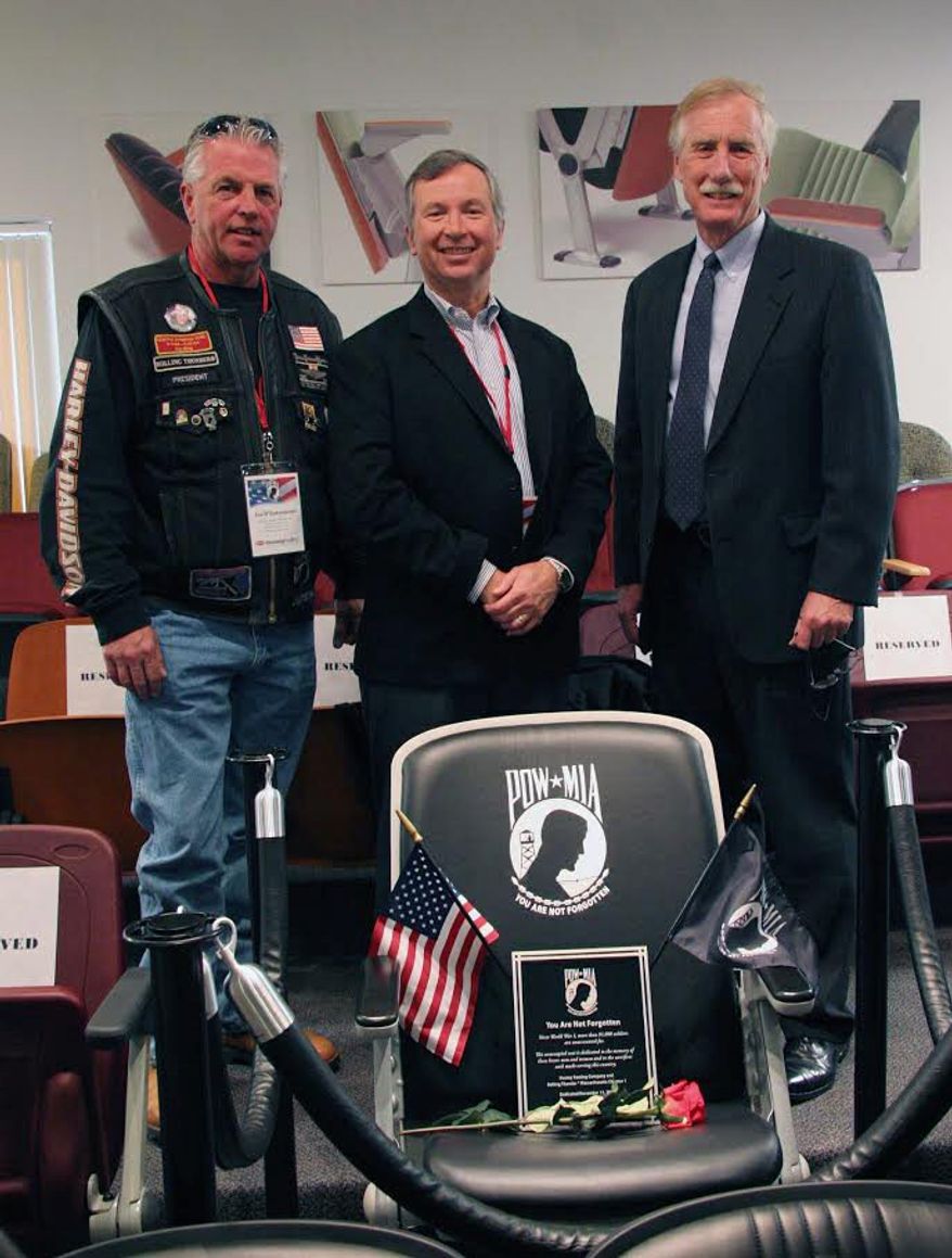 Tim Hussey, CEO of Hussey Seating Co., stands between Maine Sen. Angus S. King Jr. (right) and Rolling Thunder leader Joe D&#39;Entremont with a POW/MIA commemorative chair. The family-owned company, based in North Berwick, Maine, is a partner in the effort to place these chairs in public venues as a reminder of veterans who are missing or held captive. (Hussey Seating Co.)